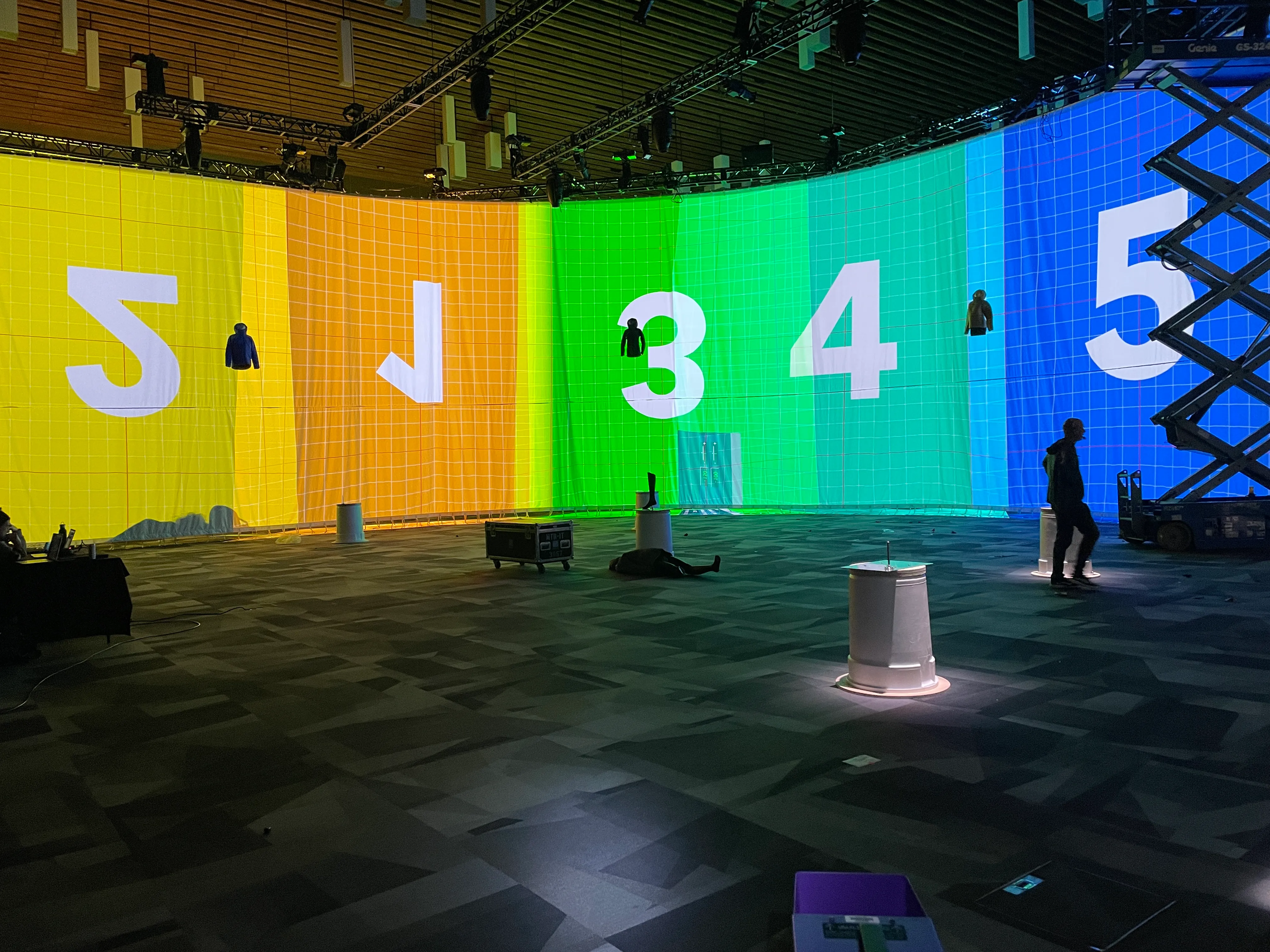 Projection wall in calibration with rainbow test pattern and scissor lift