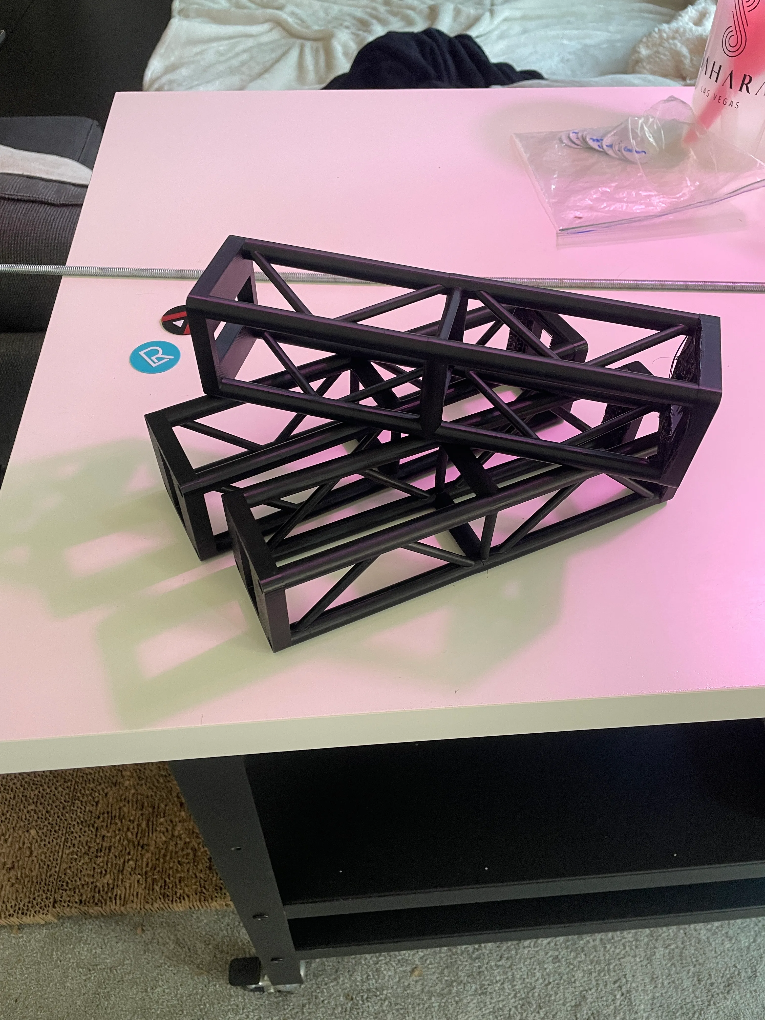 Truss sections in hand — showing internal triangulation and lattice pattern