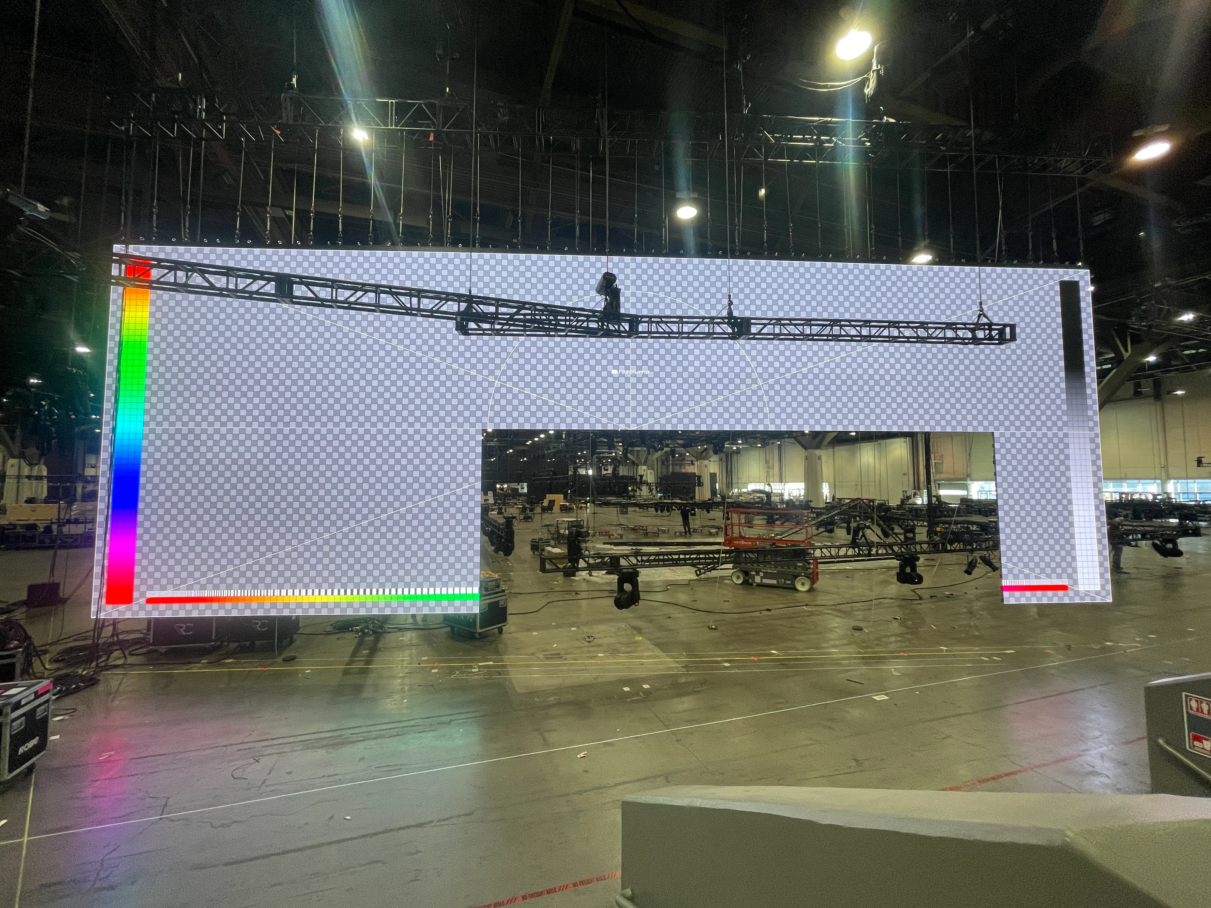Massive LED wall in Hisense CES 2025 booth mid-load-in, showing test pattern and truss rigging